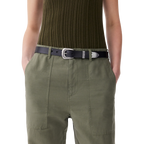 A woman wearing olive green pants with a black R.M.Williams Women's Cate Stitched Belt (BSC5FLE01) with a silver buckle on a white background.
