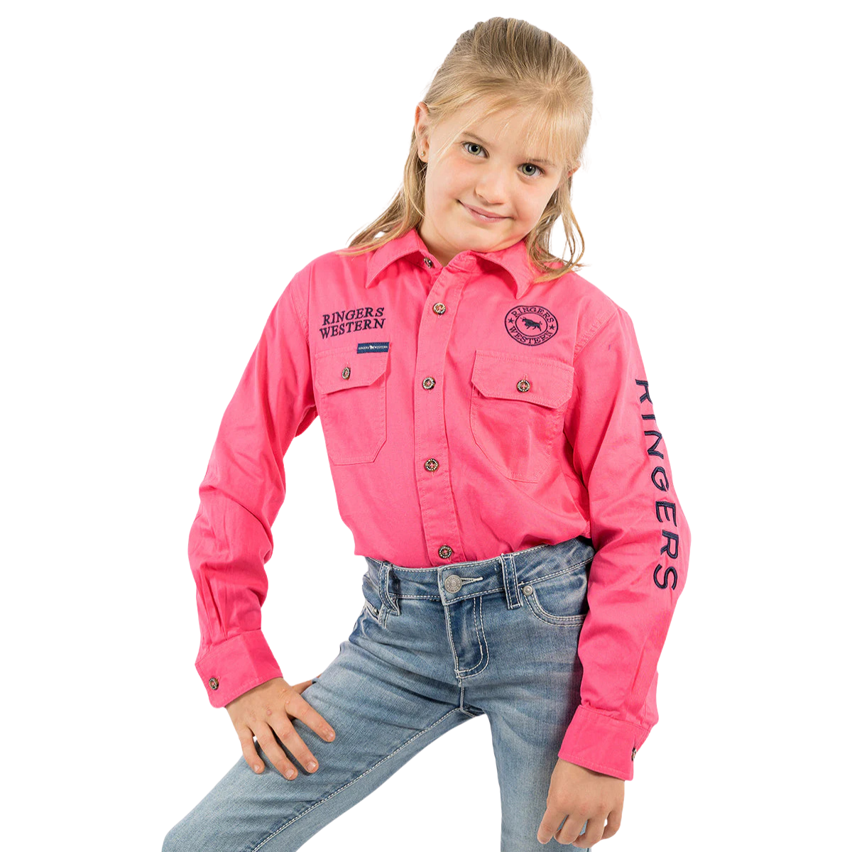 Smiling young girl in a Ringers Western Childrens Jackaroo Full Button L/S Work Shirt (Melon/Navy Embroidery) and blue jeans, standing with one hand on her hip against a white background.
