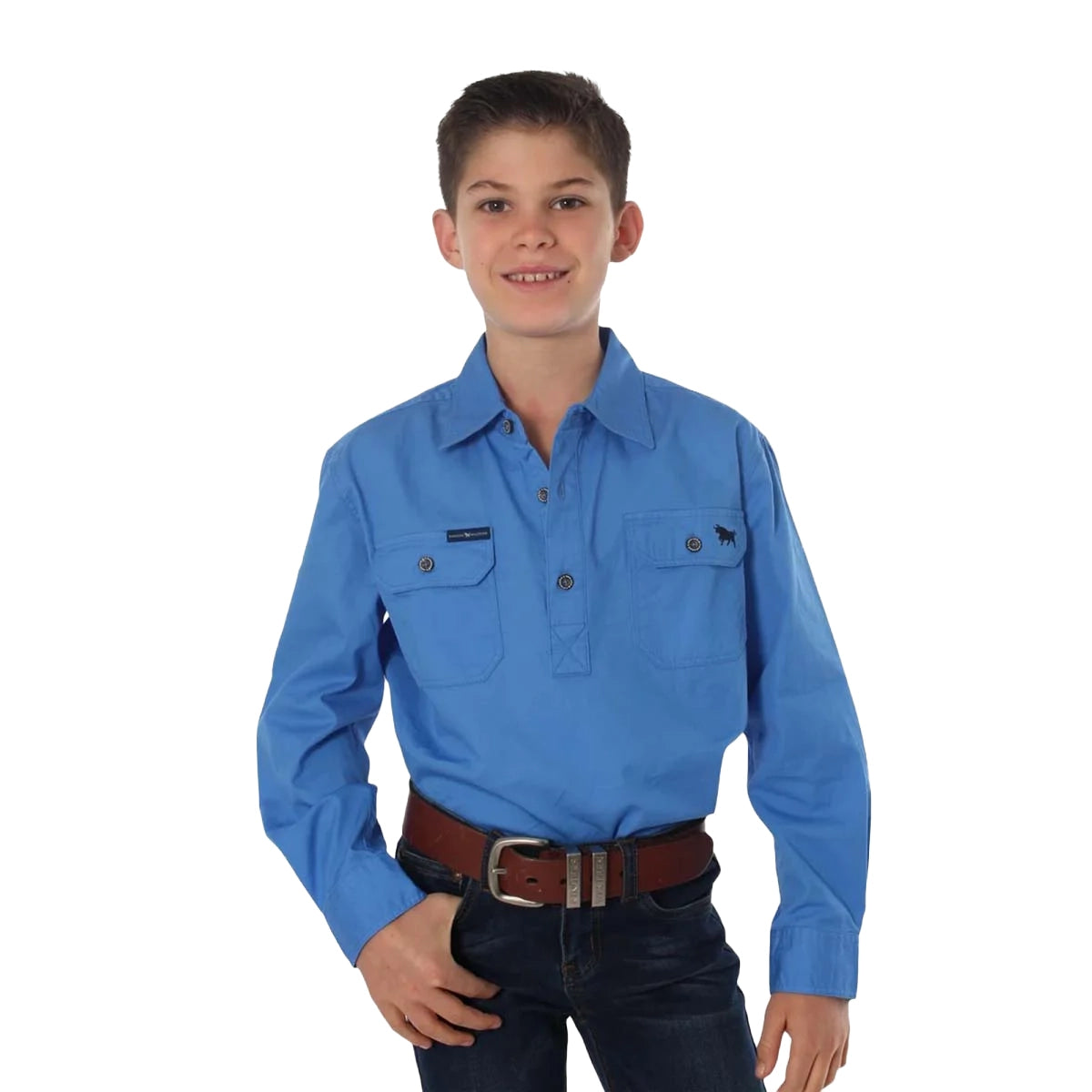 A smiling boy stands against a white background wearing the Ringers Western Childrens Ord River Half Button L/S Work Shirt (171310001) in blue, paired with dark jeans and a brown belt.