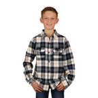 A smiling boy wears the Ringers Western Childrens Rory L/S Flannel Shirt (325026RW) in Navy/Tobacco with front pockets and western styling, standing with hands in pockets against a white background.
