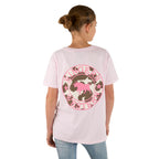A girl with a bun wears the Ringers Western Childrens Signature Bull Classic Fit S/S Tee in Barely Pink, featuring a bull logo on the back. She faces away from the camera and pairs it with light blue jeans.