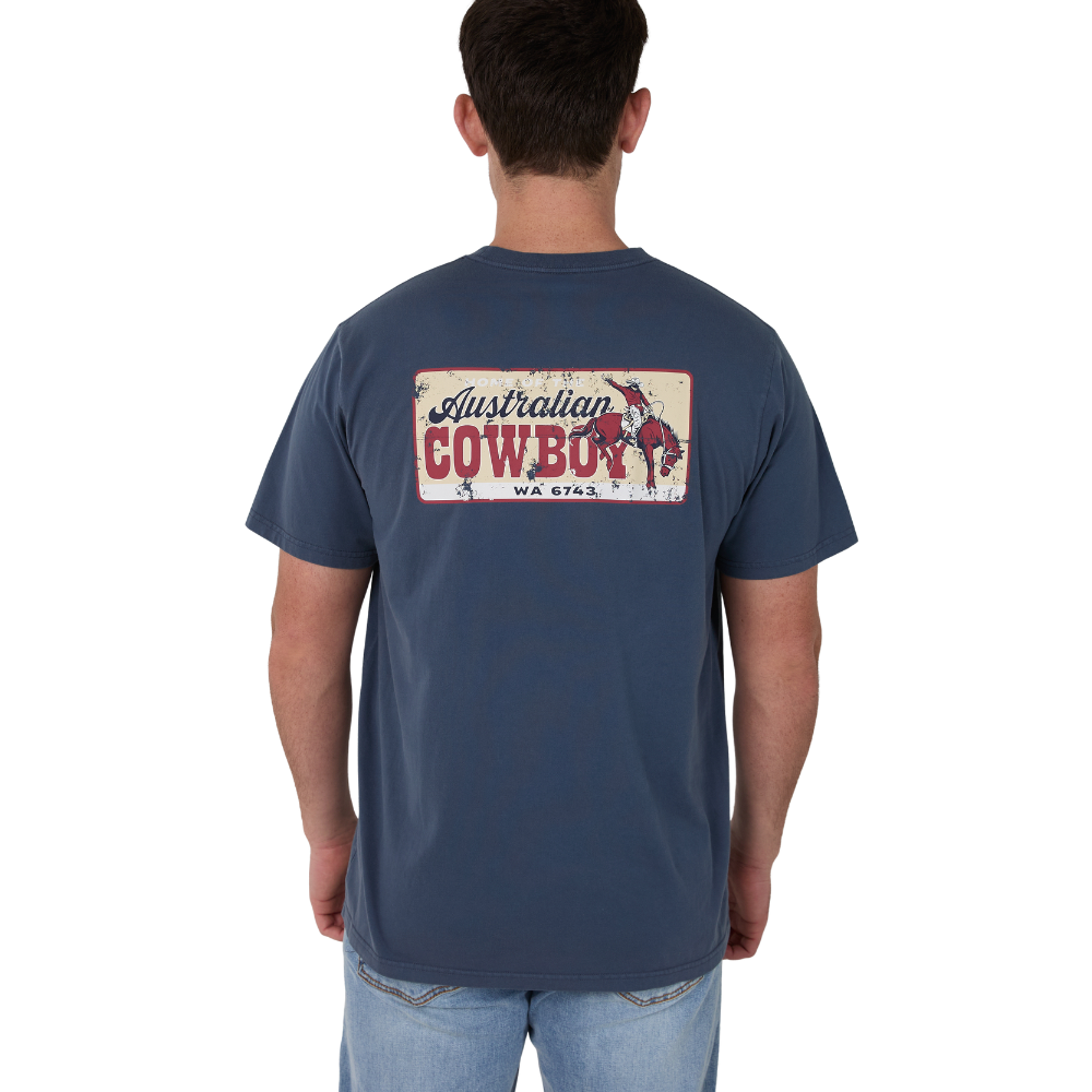 A man viewed from behind wearing a navy Ringers Western Men's Australian Cowboy Loose Fit S/S T-Shirt (125125RW) with a vintage-style 'Australian Cowboy' graphic on the back, paired with light blue jeans against a plain white background.