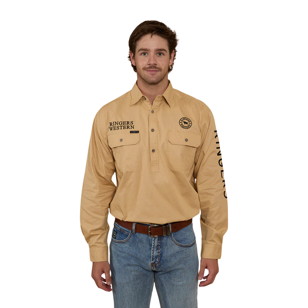 A man wearing a Ringers Western Mens Hawkeye Half Button L/S Work Shirt in Dark Sand, blue jeans, and a belt stands facing forward against a plain white background.