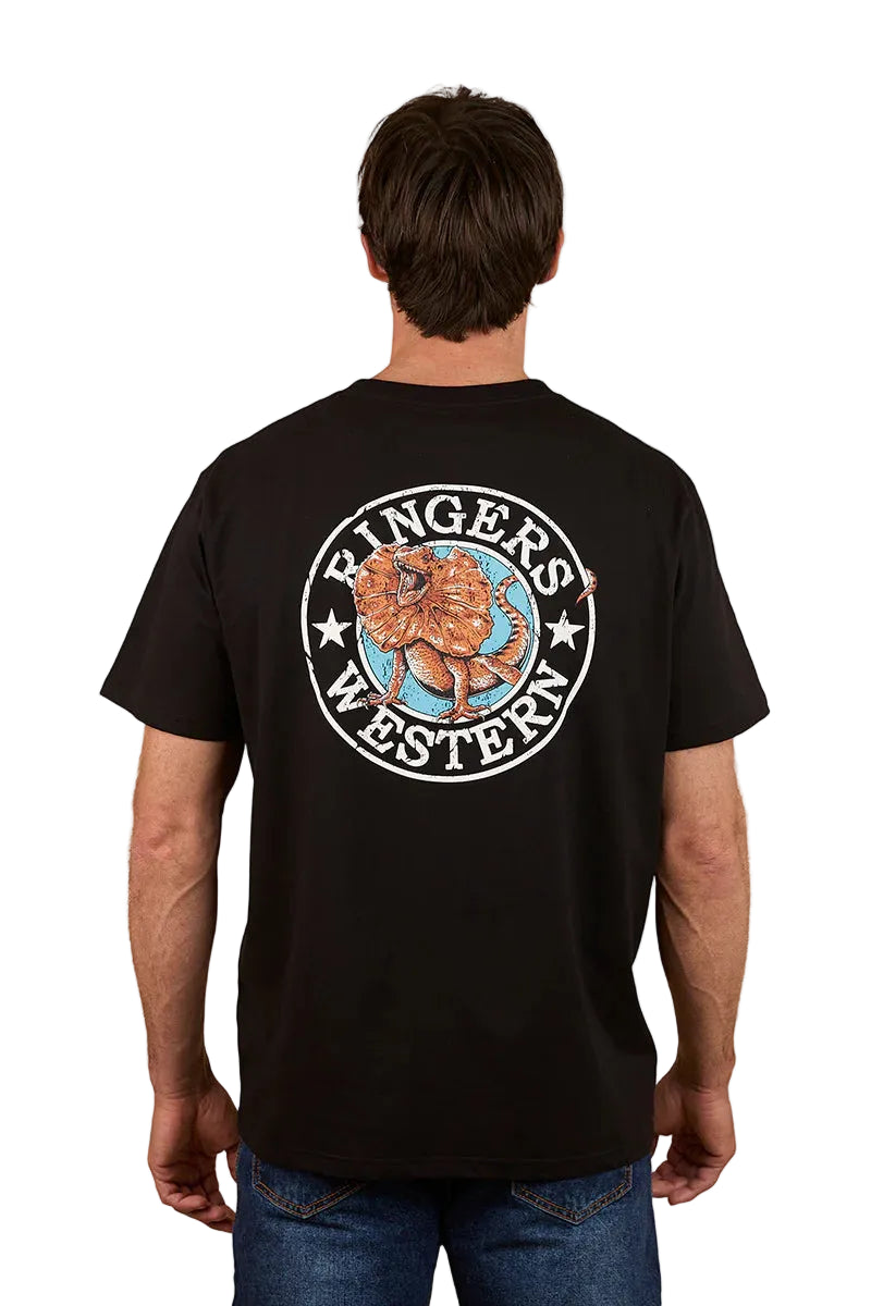 A man stands with his back to the camera, wearing the Ringers Western Mens Outta Towner Loose Fit S/S Tee in black, featuring a circular floral "Ringers Western" design—a classic Aussie outback style.