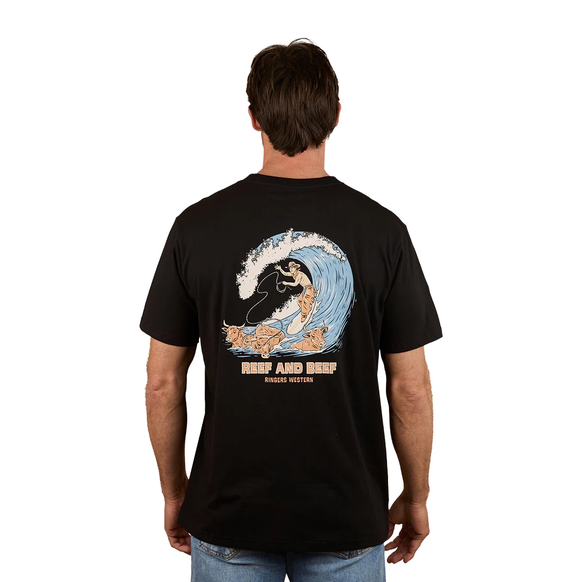 A man wears a black Ringers Western Mens Reef and Beef Loose Fit S/S Tee with a large surfer graphic and "RANCH WATER" text on the back, standing away to showcase the bold cotton crew neck design.