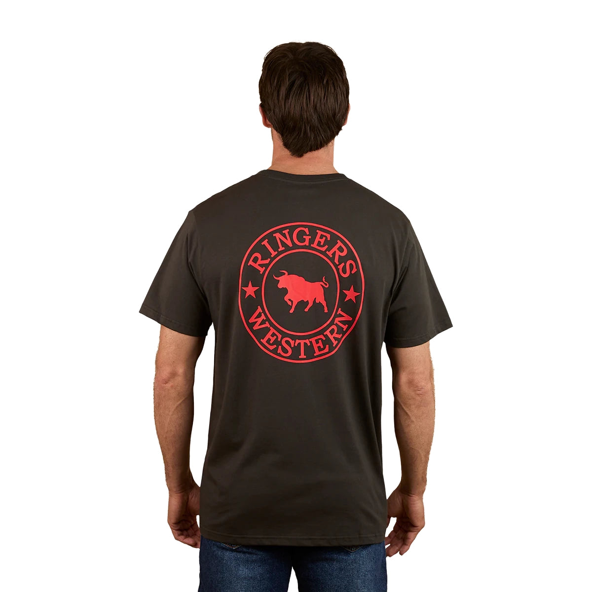 A man faces away, wearing the Ringers Western Mens Signature Bull Loose Fit S/S Tee in charcoal/red, featuring a large red circular bull logo with "RINGERS WESTERN" and stars on the back.