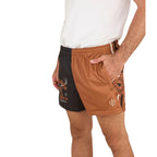 A person wearing a white shirt and Ringers Western Unisex Big Buck Footy Shorts (125019RW) in Tobacco, made from moisture-wicking polyester. Only the lower torso and upper legs are visible, highlighting a sporty country style.