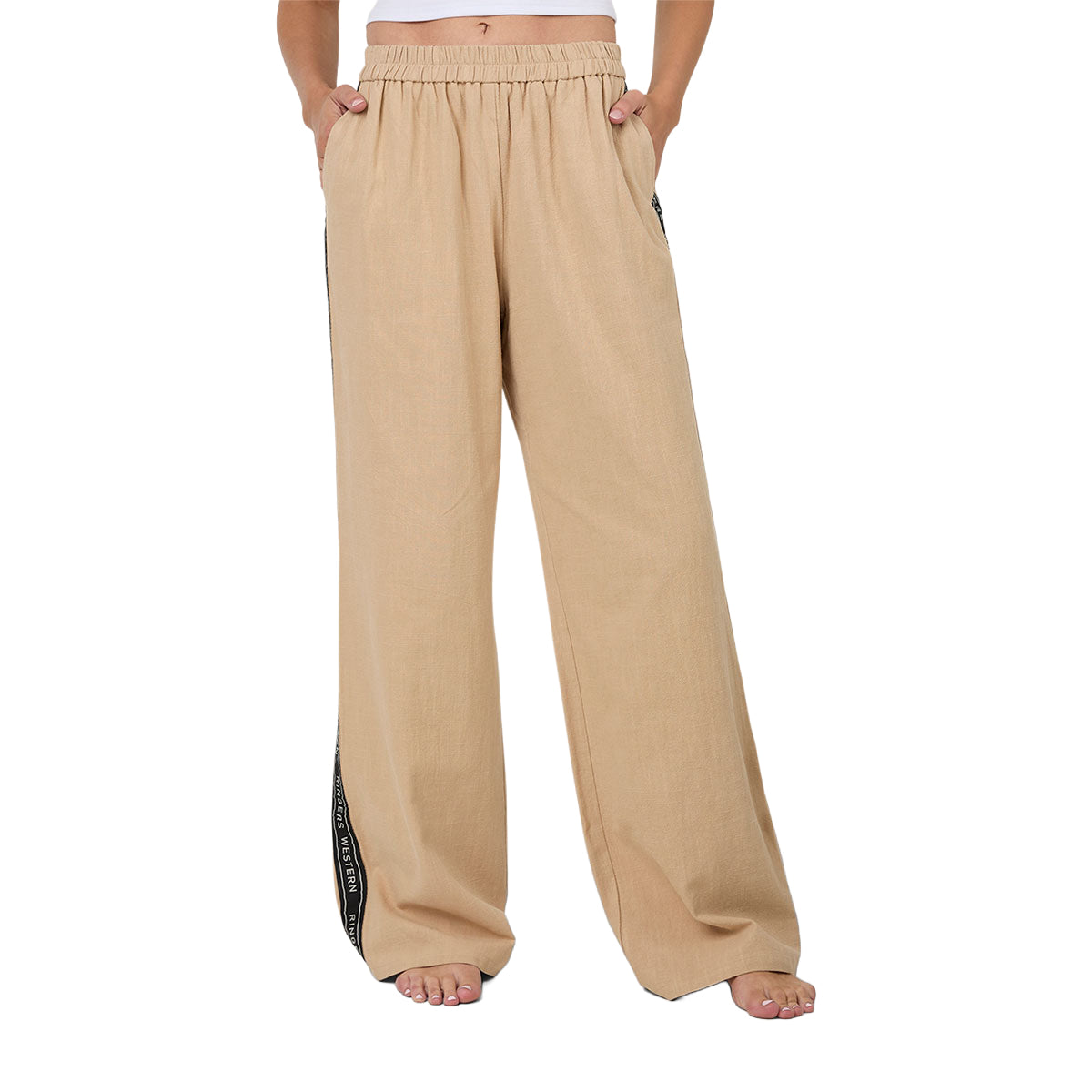 A woman wearing beige Ringers Western Alexis Elastic Waist Wide Leg Pants (225045RW) with a black side stripe featuring Ringers Western text, shown from the waist down against a plain white background.