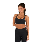 A woman in a Ringers Western Womens Anikafit Signature Crop Top (225010RW) Black stands with one hand on her hip, posing confidently and smiling slightly against a white background.