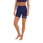 A woman wears Ringers Western Womens Anikafit Signature Shorts (225012RW) in Midnight, featuring "RING" on the left thigh, and a matching sports bra, standing barefoot against a plain white background.