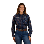 A woman with long brown hair smiles in a Ringers Western Womens Fingal Half Button L/S Flannel Shirt (224016RW) Dark Blue, paired with jeans and a brown belt—authentic Australian country style against a white background.