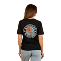 A woman with light brown hair wears the Ringers Western Womens Outta Towner Loose Fit S/S Tee in black, featuring a colorful lion crest and "Ringers Western" on the back, paired with light blue jeans for an Aussie-inspired look.