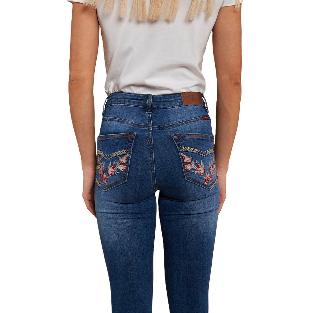 A back view of a woman modelling a pair of Vintage Blue Wash Ringers Western Women's Penny Rodeo High Rise Bootleg Jeans (222104RW) with floral embroidery on the back pockets, on a white studio background.