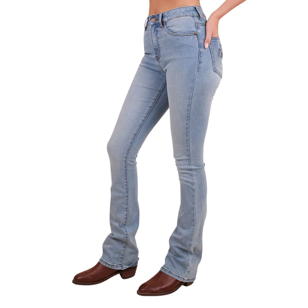 A woman viewed from the side from the waist down modelling vintage light blue Ringers Western Women's Penny Rodeo High Rise Bootleg Jeans (222104RW) with a black rodeo rider print on the back pockets, paired with brown boots on a white studio background.