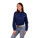 A woman with long dark hair smiles, wearing a Ringers Western Womens Pentecost River Half Button Work Shirt in Navy and blue jeans with a light coloured belt. The background is plain white.