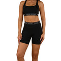 A woman models Ringers Western Womens Ringers Active Logo Elastic Pocket Shorts (225014RW) Black and a matching sports bra, both featuring branded bands, standing with hands by her sides against a white background.