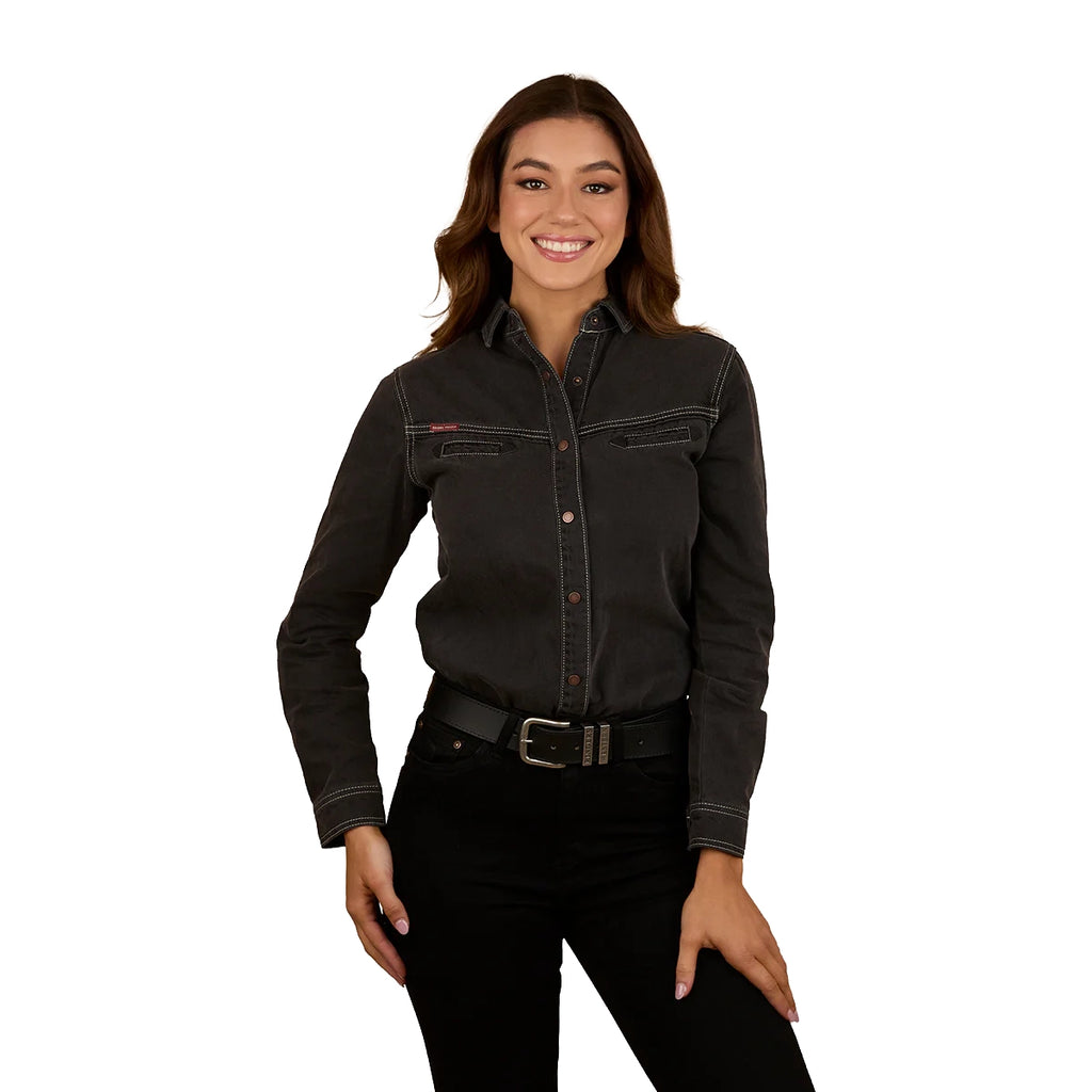 A woman with long brown hair wears the Ringers Western Womens Sarina L/S Shirt (225063RW) in washed black, paired with a black belt and pants, smiling against a white background.