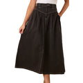 A person wears the Ringers Western Womens Sarina Midi Skirt (225062RW) in washed black, featuring white stitching and side pockets, paired with a white top. Only the lower torso and upper legs are visible, highlighting this stylish midi skirt.