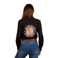 A woman with her back to the camera wears a black Ringers Western Womens Signature Jillaroo Printed Full Button L/S Work Shirt (225101RW) featuring a large logo and bull graphic, paired with blue jeans. She has brown hair down against a plain white background.