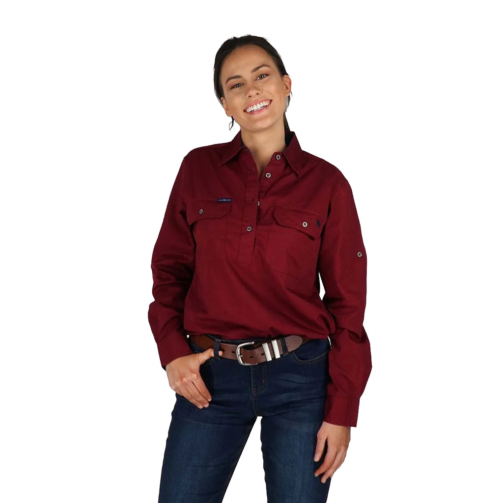 A woman smiles with one hand in her pocket, wearing the Ringers Western Womens Pentecost River Half Button Work Shirt in Burgundy, standing against a plain white background.