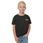 Child wearing a black t-shirt with a logo on a plain background