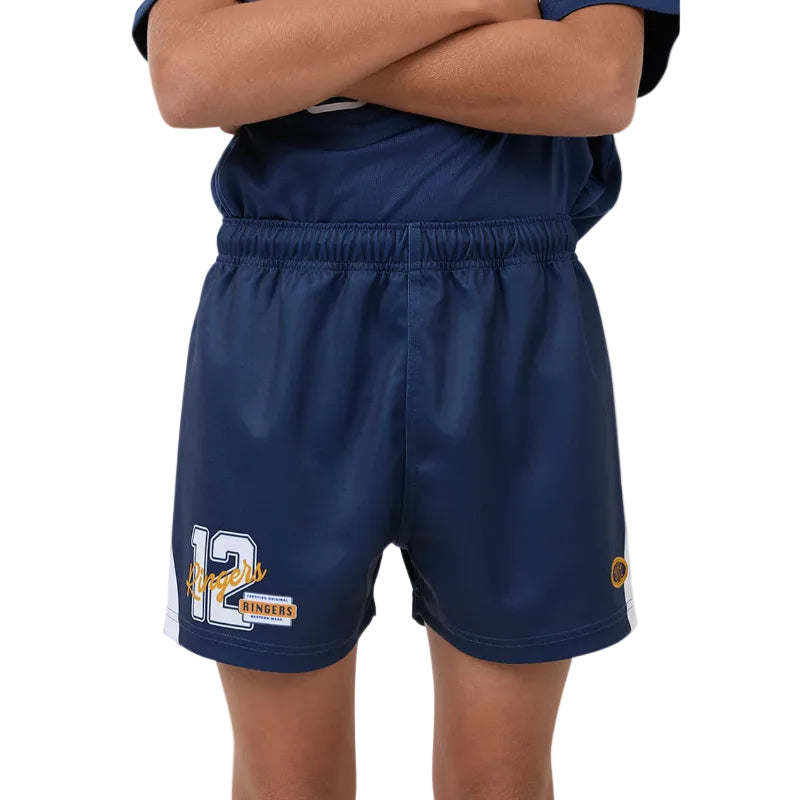 A close-up of a person wearing navy blue footy shorts with a white and yellow number 12 graphic on the left leg and a small circular logo on the right leg, paired with a matching navy top against a white background.