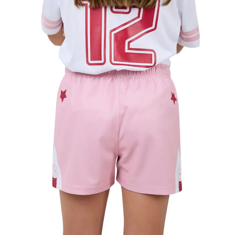 Person wearing a white shirt with red numbers and pink shorts on a plain background