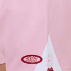Pink shorts with a red star and 2012 logo on a white background