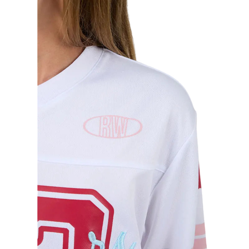 White short-sleeve shirt with red and blue graphics and a logo on a beige background