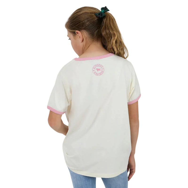 A girl from behind wearing a cream-colored ringer t-shirt with pink trim on the collar and cuffs, featuring a circular pink logo on the upper back.