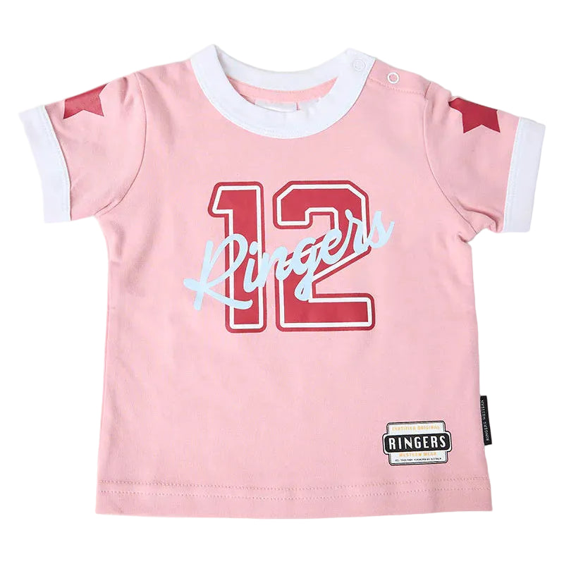 A baby pink short-sleeve t-shirt with a white ringer collar and cuffs, featuring a red '12' and light blue 'Ringers' script across the chest, with red star details on the sleeves and a brand label near the hem.