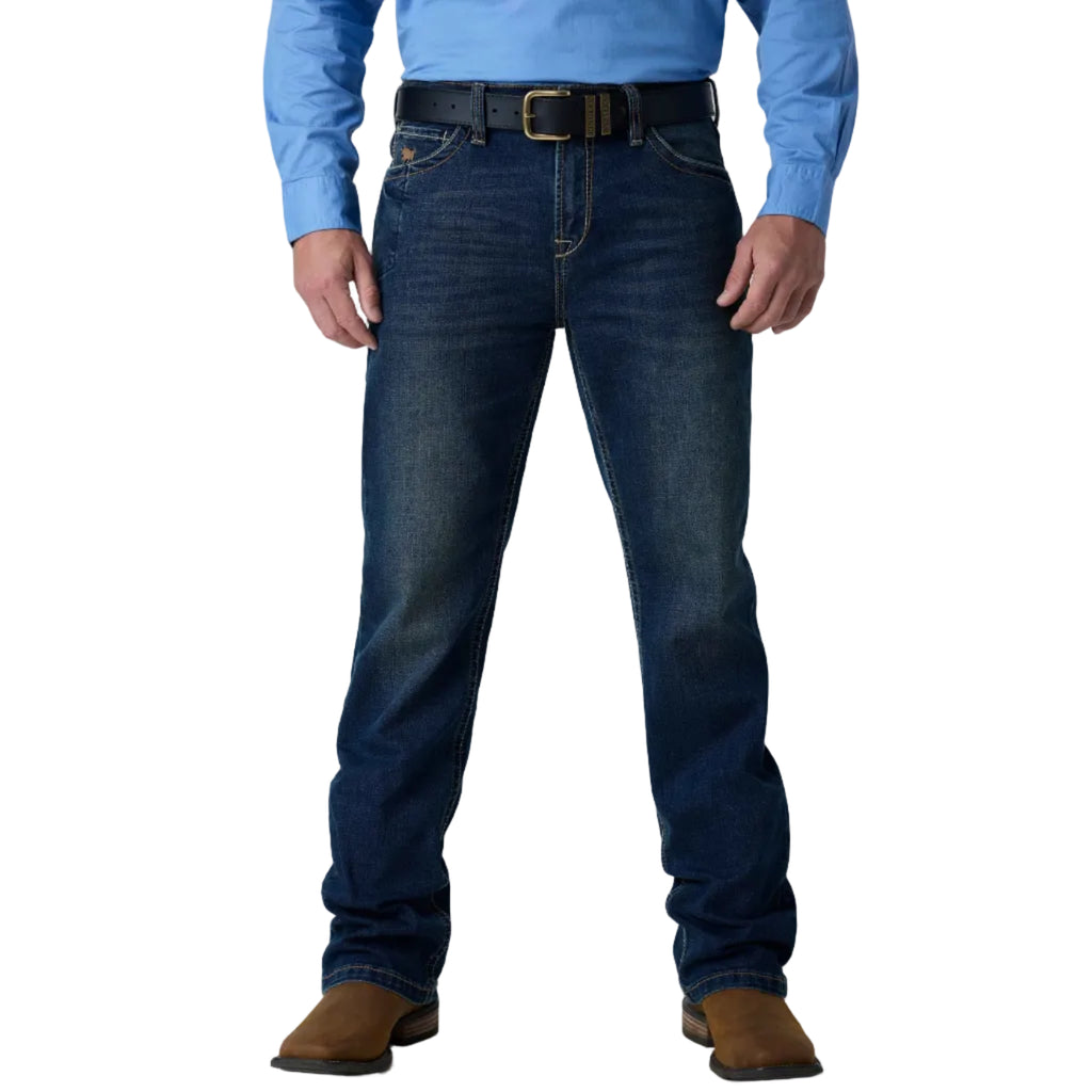A person wearing dark blue denim jeans with a black belt and brown boots, shown from the waist down against a white studio background.