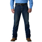 A person wearing dark blue denim jeans with a black belt and brown boots, shown from the waist down against a white studio background.