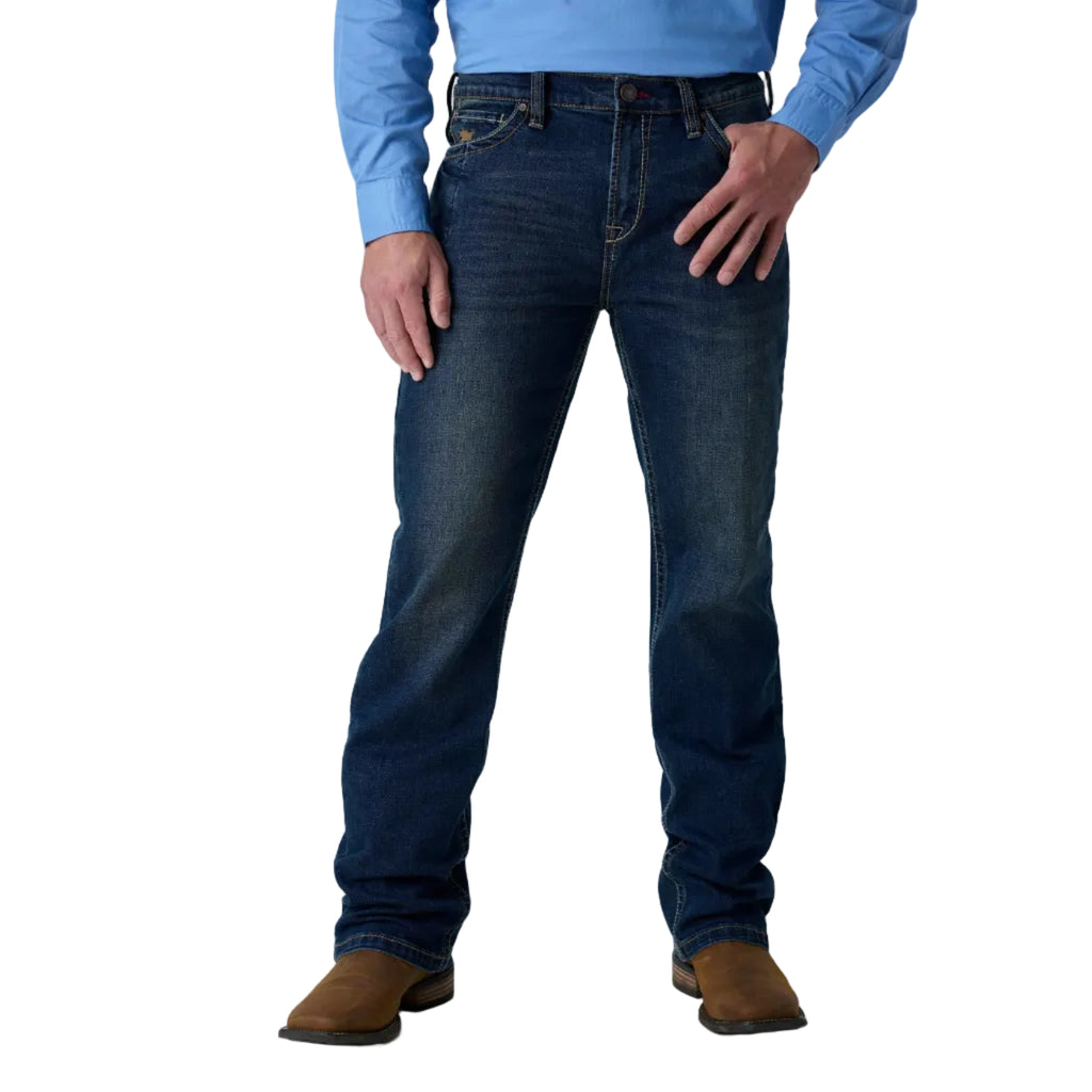 A person wearing dark blue denim jeans, a light blue long-sleeve shirt, and brown boots, shown from the waist down against a white studio background.