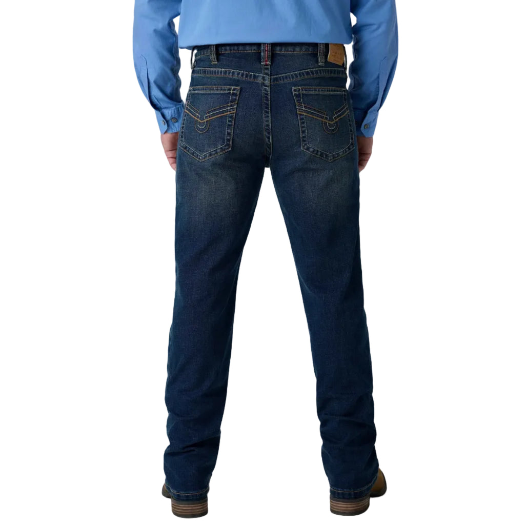 Rear view of a person wearing dark blue denim jeans with a light blue long-sleeve shirt and brown shoes, shown against a white studio background.