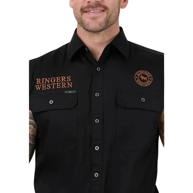 A close-up of a man wearing a black button-up shirt with 'Ringers Western' embroidered in orange on one side and a circular logo patch above the other chest pocket.