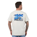 A man viewed from the back wearing a cream-coloured t-shirt with a large graphic print on the back. The graphic features three blue horses in silhouette above a blue and white semi-truck with 'Ringers Western' written on the side.