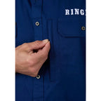 Close-up of a blue button-front shirt with a hand pulling a pocket flap, showing a white RING logo on the chest.