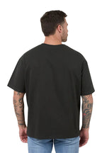Man wearing a black t-shirt with a plain back on a white background