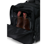 A black Ringers Western Rider Go Sports Bag (625130RW) duffel bag with 'Ringers' branding, featuring a top carry handle and showing the zipped end compartment with a pair of brown chelsea boots in it.