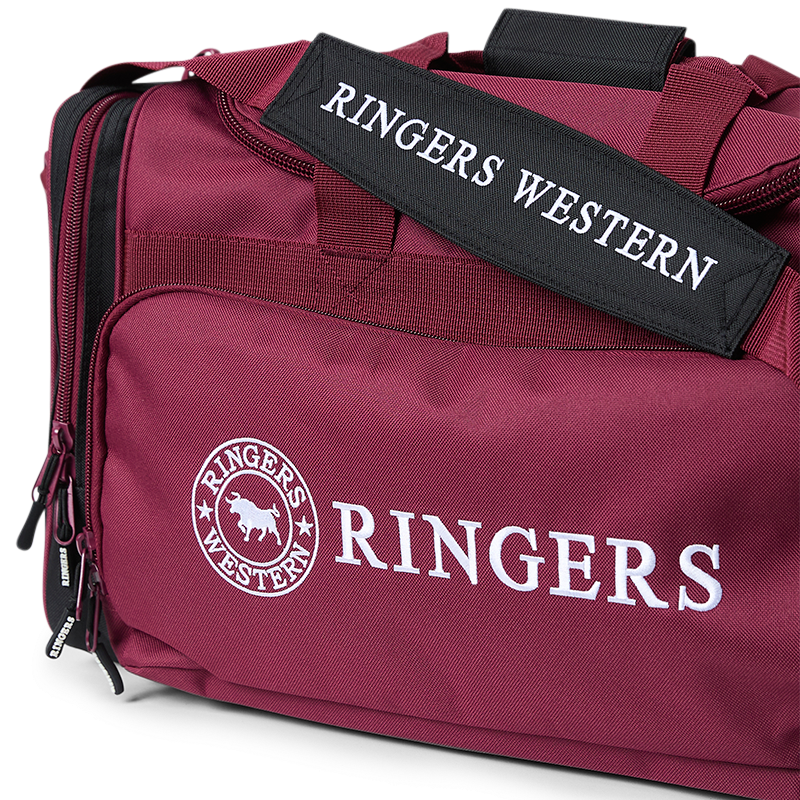 A burgundy and black Ringers Western Rider Go Sports Bag (625130RW) duffel bag with white 'Ringers' branding, featuring dual top handles, shoulder strap, a front zippered pocket, and side pockets.