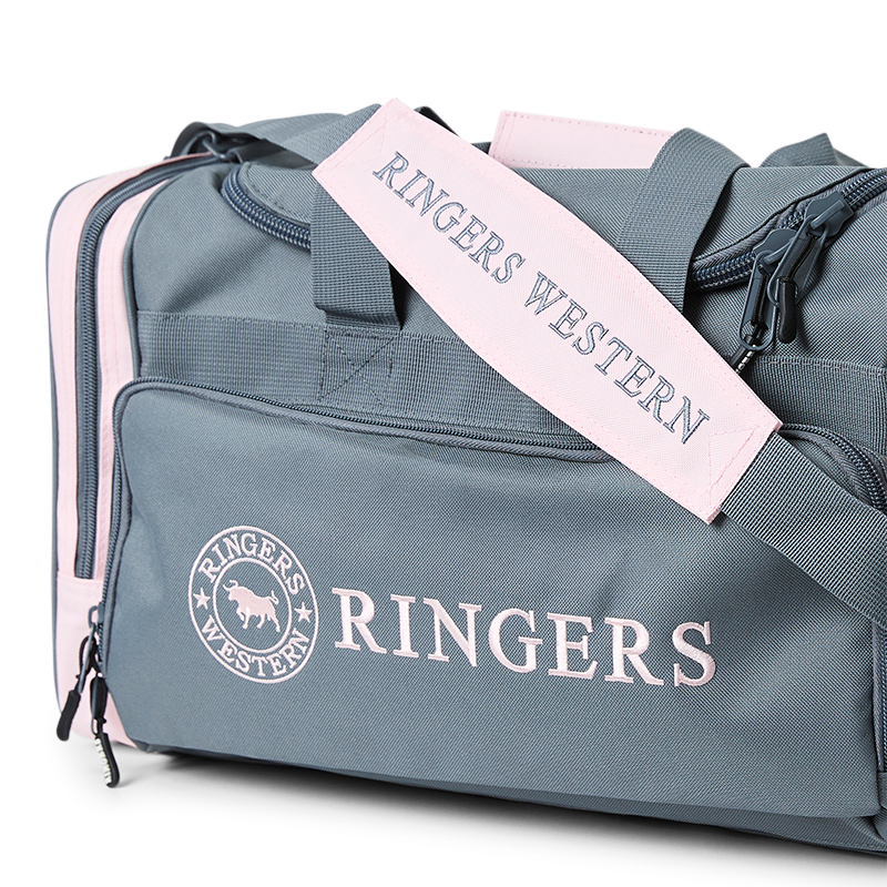A Ringers Western Rider Go Sports Bag (625130RW) duffel bag in charcoal and pastel pink, featuring the brand logo on the front and side, with top carry handles and shoulder strap with 'Ringers Western' and zippered compartments on a white background.