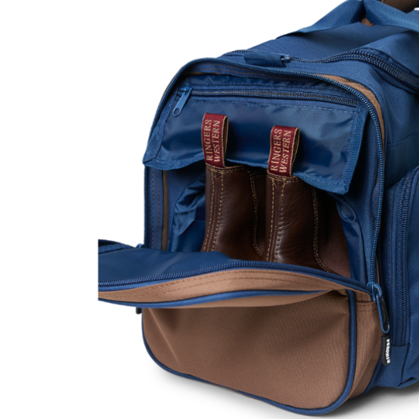 A navy and brown Ringers Western Rider Go Sports Bag (625130RW) duffel bag with 'Ringers' branding, featuring a top carry handle and showing the zipped end compartment with a pair of brown chelsea boots in it.