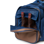 A navy and brown Ringers Western Rider Go Sports Bag (625130RW) duffel bag with 'Ringers' branding, featuring a top carry handle and showing the zipped end compartment with a pair of brown chelsea boots in it.