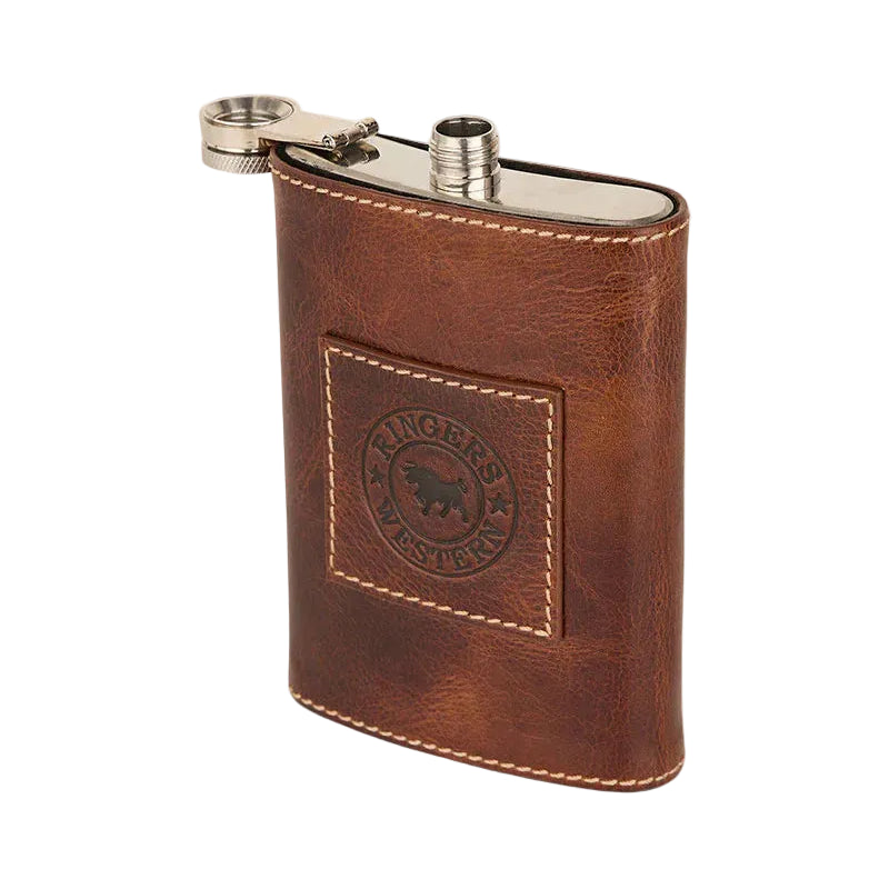A brown leather flask cover with a silver metal flask visible at the top, featuring a stitched square patch with a logo on a white background.