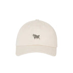 A light beige baseball cap featuring a small embroidered gray pig logo on the front, set against a solid white background.