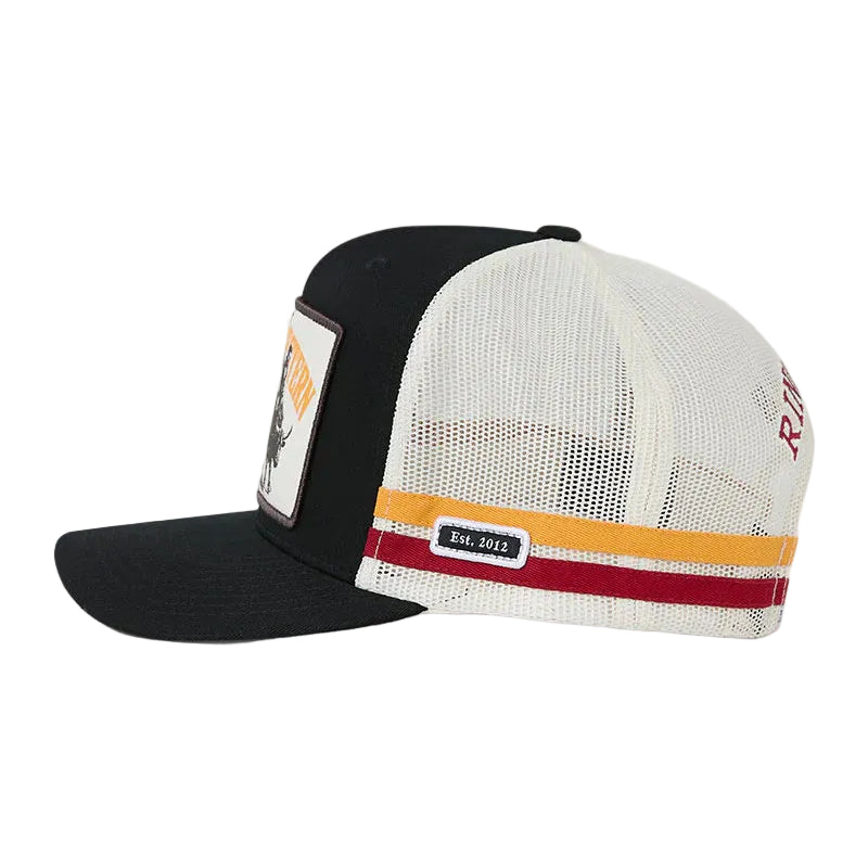 A black and white trucker-style cap with a white mesh back, a black visor, and a horizontal stripe detail in orange and red on the side. A small black patch on the side.