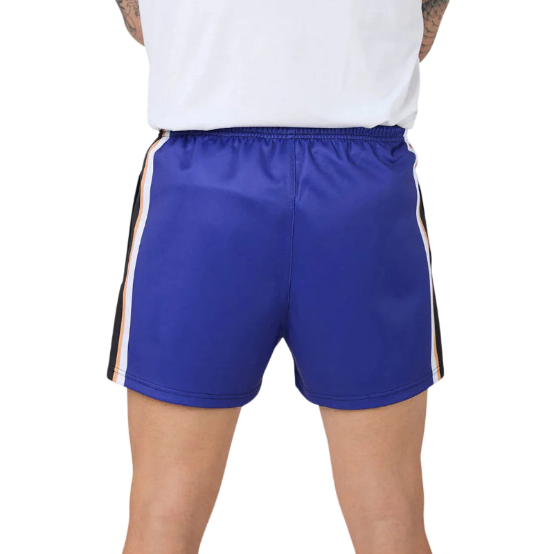 A close-up back view of a person wearing royal blue athletic shorts with white and black side stripes, paired with a white top against a white background.