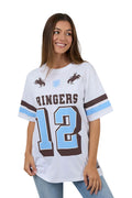 Woman wearing a white sports jersey with 'Ringers' and number '12' on a plain background