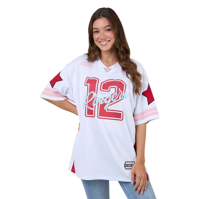 Woman wearing a white sports jersey with red and pink details on a plain background
